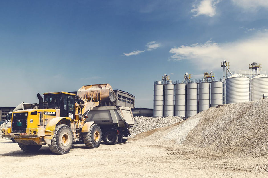 A bulldozer on a sandy construction site with a clear blue sky in the background